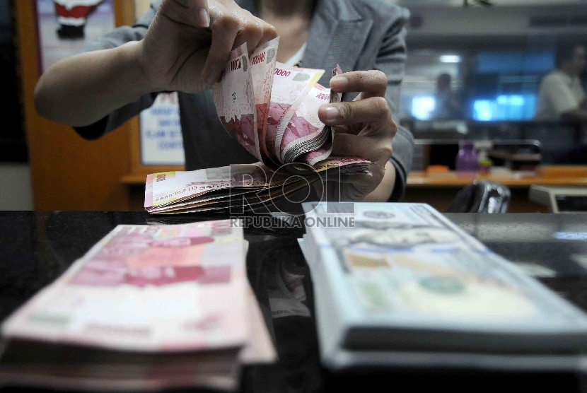  Karyawati menghitung mata uang rupiah di salah satu tempat penukaran valuta asing di Jakarta, Selasa (15/12).