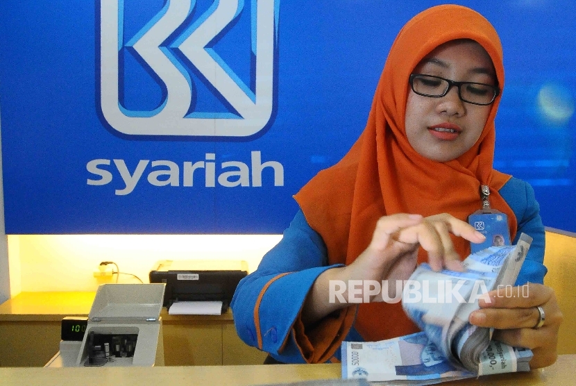 Karyawati menghitung uang di Banking Hall Bank BRI Syariah, Jakarta, Kamis (11/8). (Republika/Agung Supriyanto)