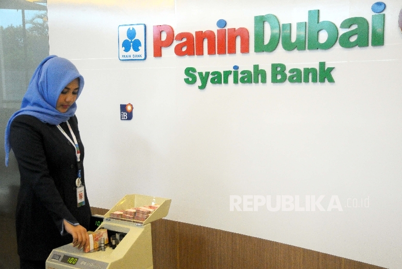 Karyawati menghitung uang di banking hall Bank Panin Dubai Syariah, Jakarta. PT Bank Panin Dubai Syariah Tbk (PNBS) mencatatkan laba bersih sebesar Rp 250,53 miliar pada 2022.