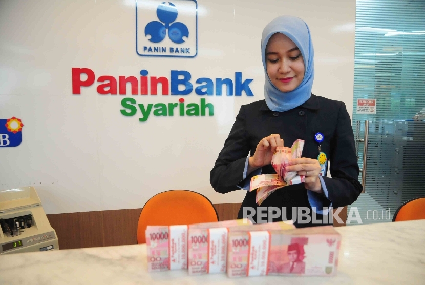 Karyawati menghitung uang di Banking Hall Bank Panin Syariah Jakarta, Kamis (14/4).  (Republika/Agung Supriyanto)