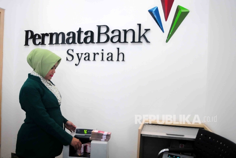 Karyawati menghitung uang di Banking Hall Bank Permata Syariah, Jakarta, Senin (9/5). (Republika/Agung Supriyanto)
