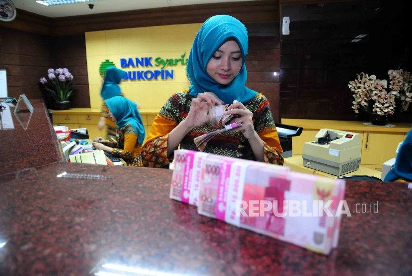 Karyawati menghitung uang di banking hall Bank Syariah Bukopin (BSB).  (Republika/ Agung Supriyanto)