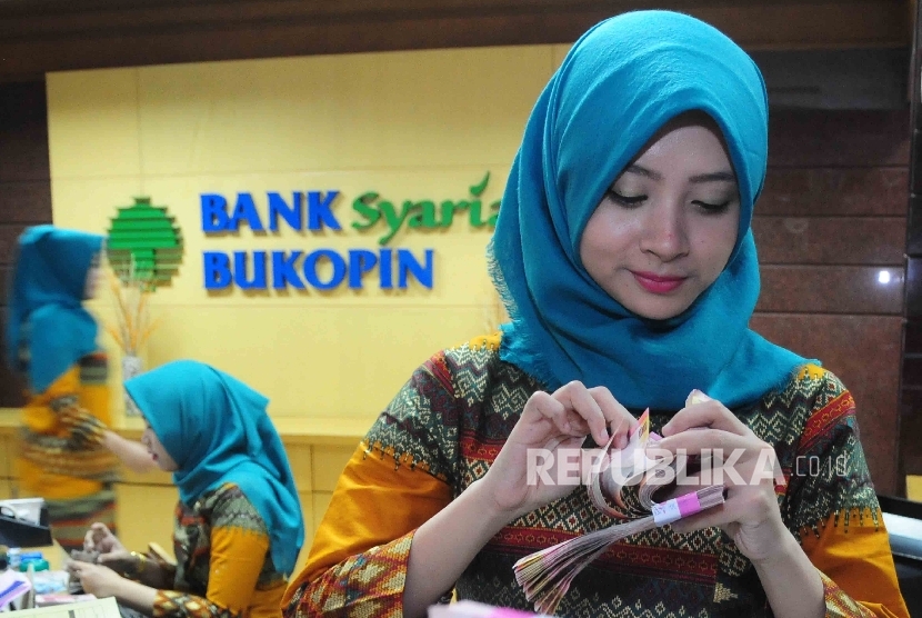 Karyawati menghitung uang di banking hall Bank Syariah Bukopin (BSB).  (Republika/ Agung Supriyanto)