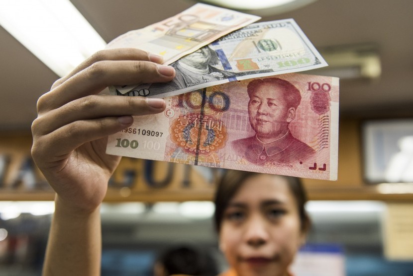 Karyawati menunjukkan mata uang Yuan di salah satu tempat penukaran valuta asing di Jakarta.