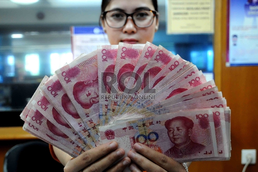 Karyawati menunjukkan mata uang Yuan di salah satu tempat penukaran valuta asing di Jakarta, Senin (30/11).  (Republika/Agung Supriyanto)