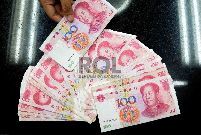 Karyawati menunjukkan mata uang Yuan di salah satu tempat penukaran valuta asing di Jakarta, Senin (30/11).  (Republika/Agung Supriyanto)
