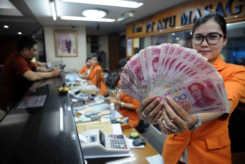 Karyawati menunjukkan mata uang Yuan di salah satu tempat penukaran valuta asing. (Republika/Agung Supriyanto)