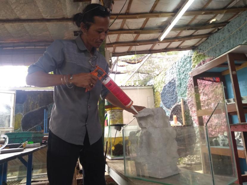 Karyono sedang menyelesaikan pembuatan hiasan untuk aquaspace di Rumah Pangan RW 06, Senin (28/12).