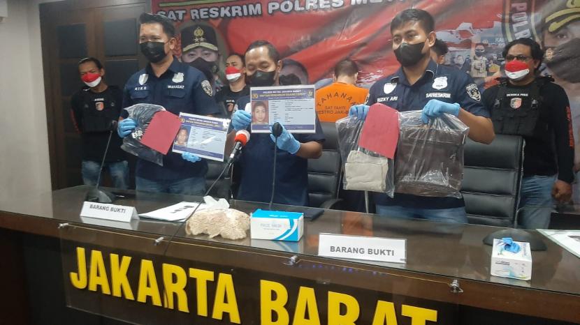 Kasat Reskrim Polres Metro Jakarta Barat Kompol Joko Dwi Harsono mengangkat barang bukti penangkapan dua copet spesialis dalam lift mal di Markas Polres Metro Jakarta Barat, Rabu (25/8).
