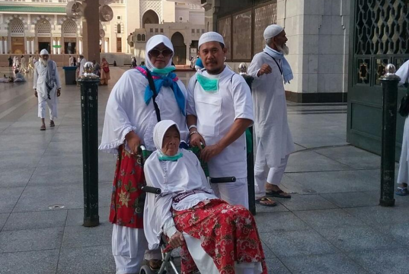Yumnah (duduk di kursi roda) pergi ke Baitullah bersama anaknya.