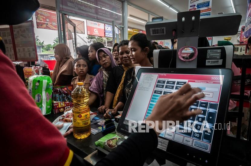 Kasir melayani warga yang membeli minyak goreng di salah satu ritel modern di Lebak, Banten, Sabtu (19/2/2022). Kelangkaan stok dan mahalnya harga minyak goreng di daerah tersebut mengakibatkan warga setempat rela mengantre untuk mendapatkan minyak goreng kemasan subsidi dari pemerintah. 