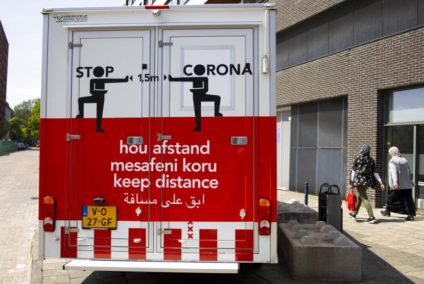 Tampak sebuah truk di Amsterdam, Belanda, memuat ajakan untuk menjaga jarak dalam empat bahasa, Selasa (26/5).