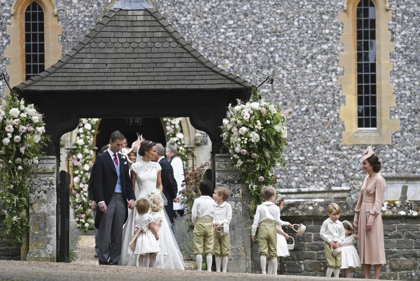Kate Middleton (kanan) memandang adiknya Pippa Middleton yang baru menikah dengan James Matthews.