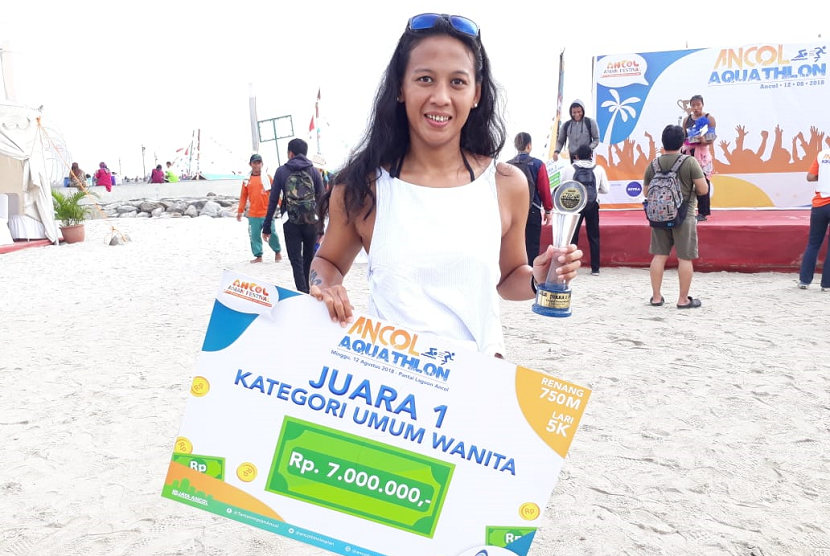 Kathriana Mella, juara 1 kategori umum wanita pada kompetisi Ancol Aquathlon 2018 di Pantai Lagoon Ancol, Jakarta, Ahad (12/8).   