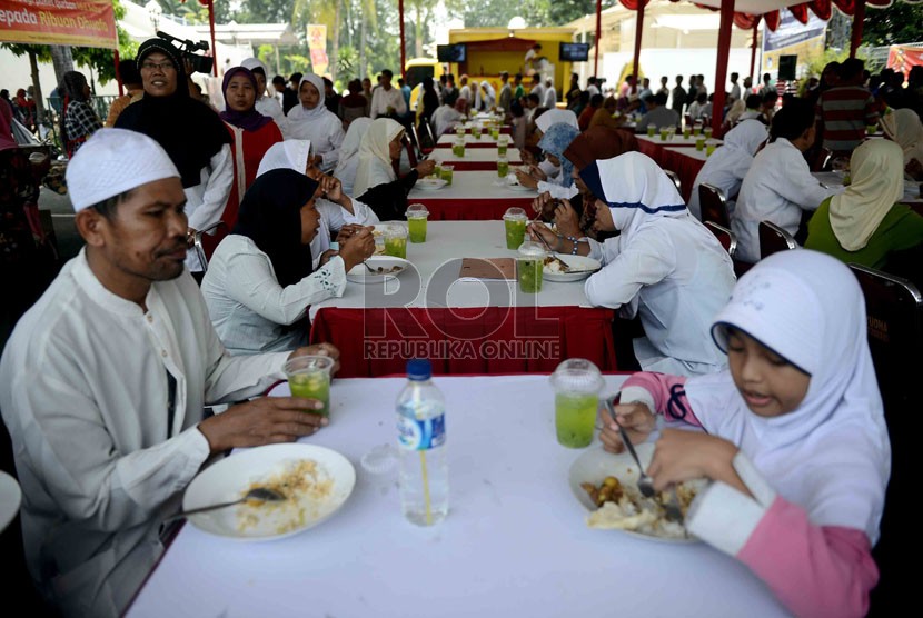   Kaum dhuafa mengikuti makan siang bersama saat dapur peduli Idhul Adha 2013 di pelataran masjid Al-Azhar, Jakarta, Rabu (16/10).  (Republika/Agung Supriyanto)