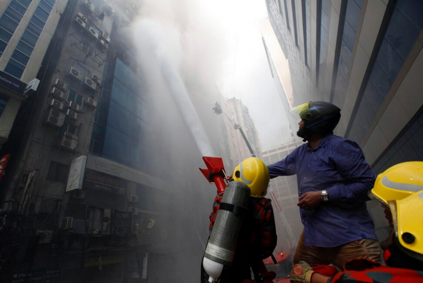 Kebakaran di Dhaka. Pengendara melihat kebakaran yang terjadi di Dhaka, Banglades, Kamis (28/3)