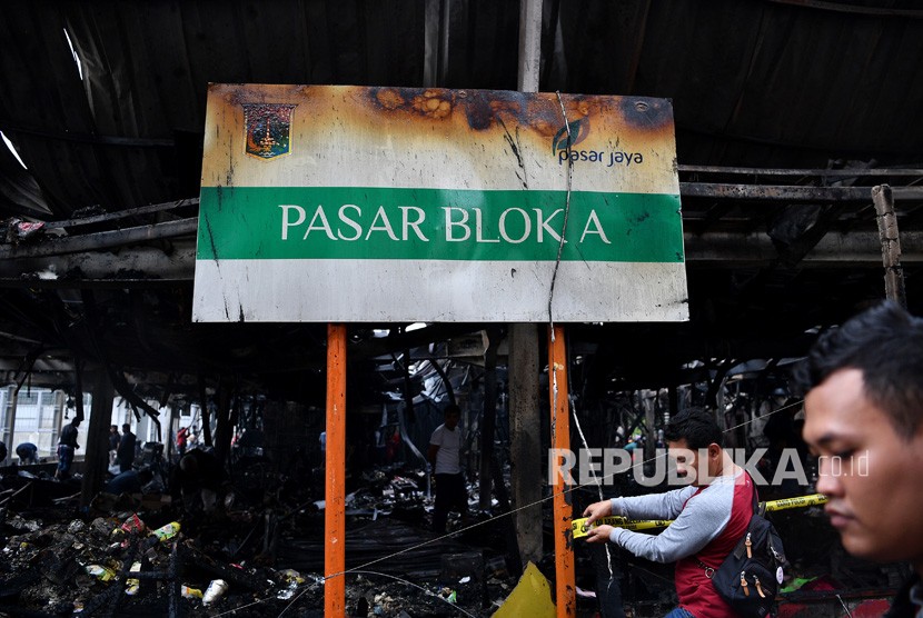 Kebakaran Pasar Blok A. Polisi dengan pakaian preman memasang garis polisi di lokasi kebakaran Tempat Penampungan Sementara Pasar Blok A, Kebayoran Baru, Jakarta Selatan, Rabu (6/3/2019). 