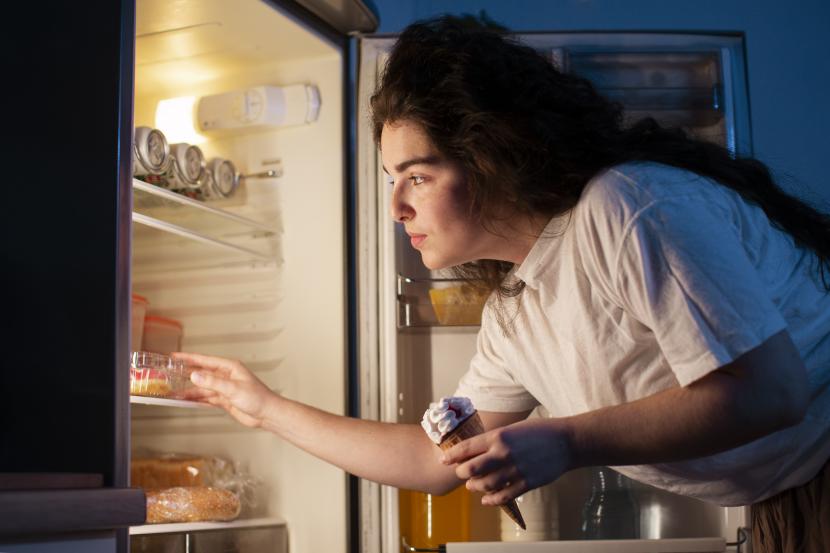 Mencari kudapan di kulkas pada malam hari (Ilustrasi). Makan mendekati waktu tidur itu memiliki implikasi kesehatan yang negatif.