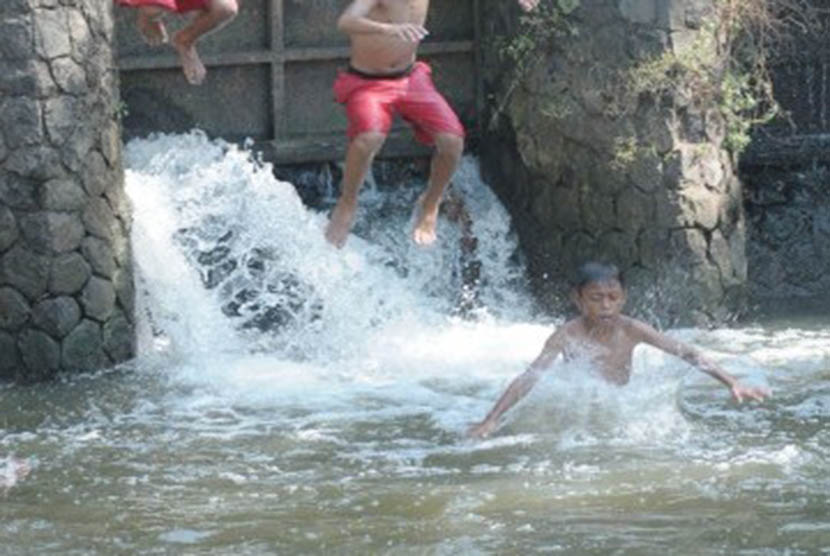 Keceriaan para bocah ketika bermain air terlihat di saluran irigasi di kawasan Neglasari, Tangerang, Banten, Rabu (14/9). Bermain air menjadi cara mereka untuk mengusir panasnya selama kemarau. (Republika/Aditya)