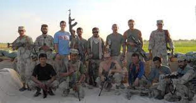 Keempat dari kiri, barisan belakang, Zabiullah Zyah, yang bekerja sebagai penerjemah untuk militer AS di Afghanistan selama kurang dari dua tahun antara 2010 dan 2012, berfoto bersama tim Penembak Jitu Marinir AS dan Pasukan Keamanan Nasional Afghanistan di sebuah pos pemeriksaan dekat kota Marjah, provinsi Helmand.