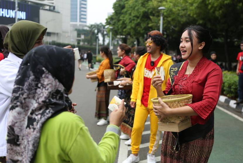 Kegiatan bagi-bagi jamu gratis kepada masyarakat  yang hadir di acara Car Free Day (CFD) di kawasan Bundaran HI, Jakarta. 