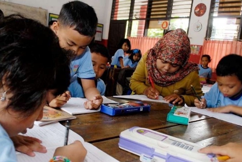 Guru (tengah)  berinteraksi pada kegiatan  belajar mengajar di Sd Negeri 1, daan Mogot, Tangerang, banten, Selasa  (2/9).