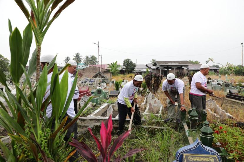 Kegiatan gotong royong membersihkan area tempat pemakaman umum (TPU) milik masyarakat di Jalan Marelan Raya Pasar III, Kecamatan Medan Marelan, Kota Medan, Sumatra Utara. 