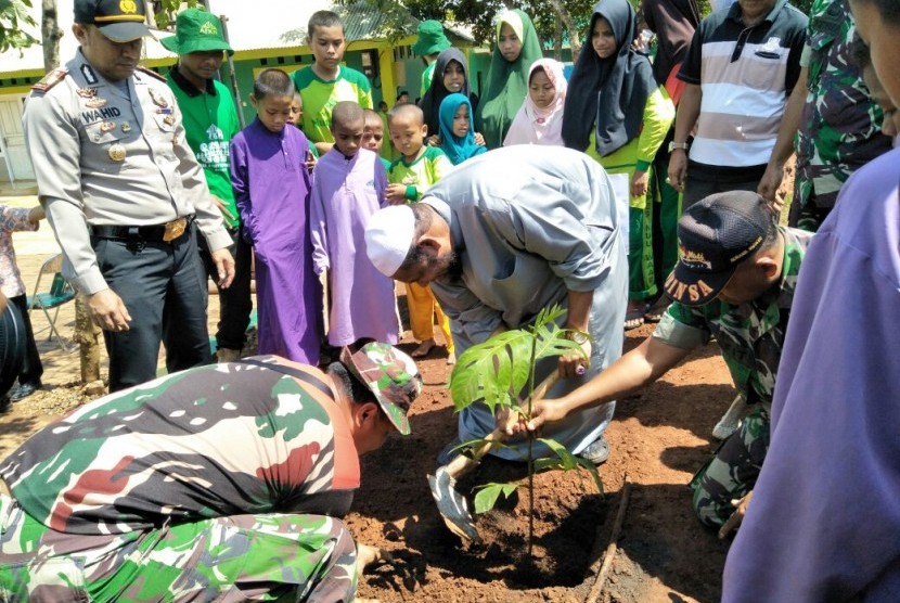 Kegiatan menanam 300 pohon sukun bersama Kapolsek, Koramil, dan Jajaran Petugas Kecamatan Setu, di Pondok Pesantren Nuu Waar, Jumat (9/3). 