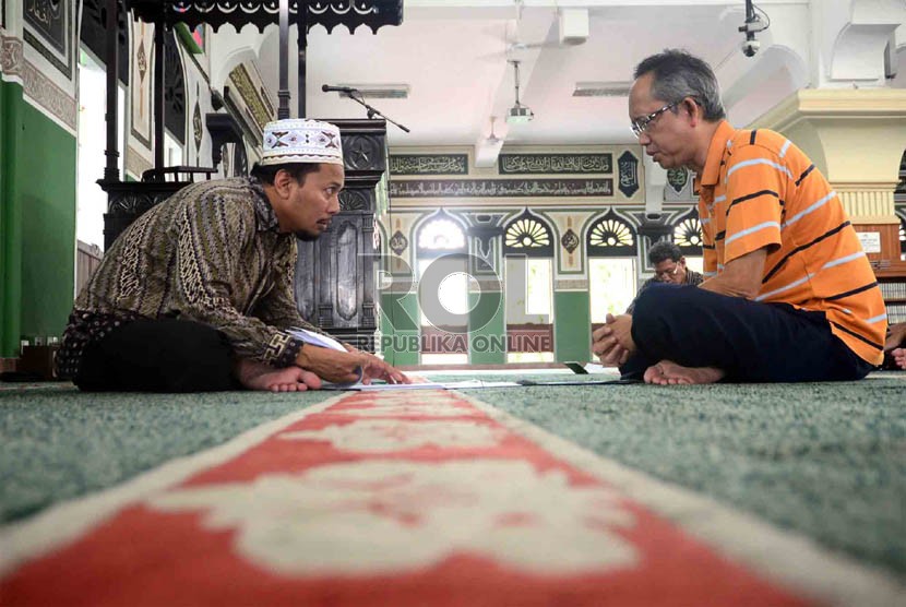Ketua Lembaga Tahfizh Al-Azhar, Achmad Khotib (kiri) membimbing jamaah peserta Program Hafalan Alquran di Masjid Al-Azhar, Jakarta, Ahad (9/6).  (Republika/Agung Supriyanto)  
