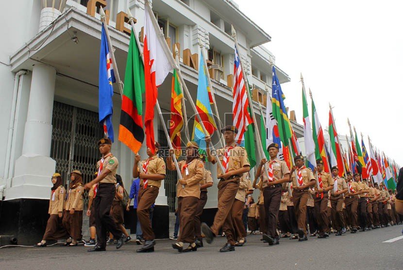  Kelompok anggota Pramuka berkarnaval sambil membawa bendera negara-negara peserta KAA di Jalan Asia-Afrika, Bandung, Kamis (18/4).  (Republika/Arief Maulana Hasan)