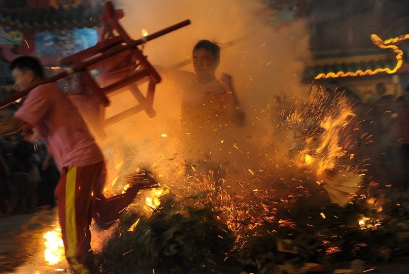 Kelompok kesenian melompati kobaan api saat malam puncak perayaan Cap Go Meh