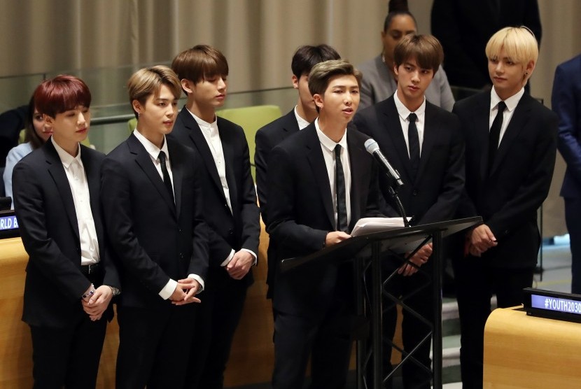 Kelompok musik Korea BTS, dengan RM berdiri di podium.