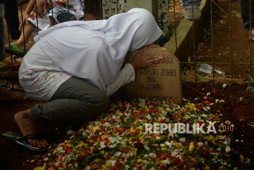 Keluarga Almarhum Damanhuri Zuhri mencium pusara usai pemakaman di Parung, Bogor, Jawa Barat, Senin (2/1). Kang Daman meninggal akibat penyakit pada Senin (2/1) pagi. 