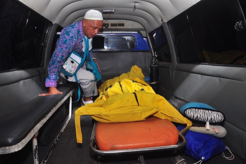  Keluarga berada di samping kantong jenazah seorang jamaah haji yang meninggal dunia di pesawat di Embarkasi Donohudan, Kabupaten Boyolali, Jawa Tengah, Kamis (8/10) malam.