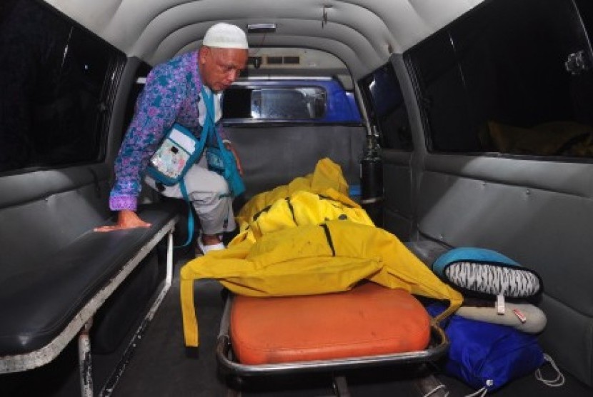Keluarga berada di samping kantong jenazah seorang jamaah haji yang meninggal dunia di pesawat di Embarkasi Donohudan, Boyolali, Jawa Tengah, Kamis (8/10) malam. 