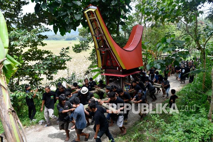 Keluarga duka mengarak jenazah saat prosesi penguburuan pada upacara pemakaman adat Toraja atau Rambu Solo di Sangalla, Tana Toraja, Sulawasi Selatan, Jumat (25/2/2022). Prosesi penguburan tersebut dilakukan untuk mengantar jenazah ke liang kubur dan merupakan rangkaian terakhir Rambu Solo. 