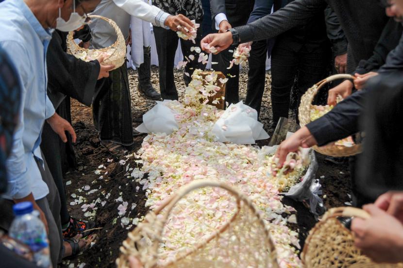 Keluarga Gubernur Jawa Barat Ridwan Kamil menabur bunga di pusara Emmeril Kahn Mumtadz usai prosesi pemakaman di Cimaung, Banjaran, Kabupaten Bandung, Jawa Barat, Senin (13/6/2022). Emmeril Kahn dimakamkan di lokasi yang akan dijadikan Islamic Center Al Mumtadz yang di desain sendiri oleh Ridwan Kamil.