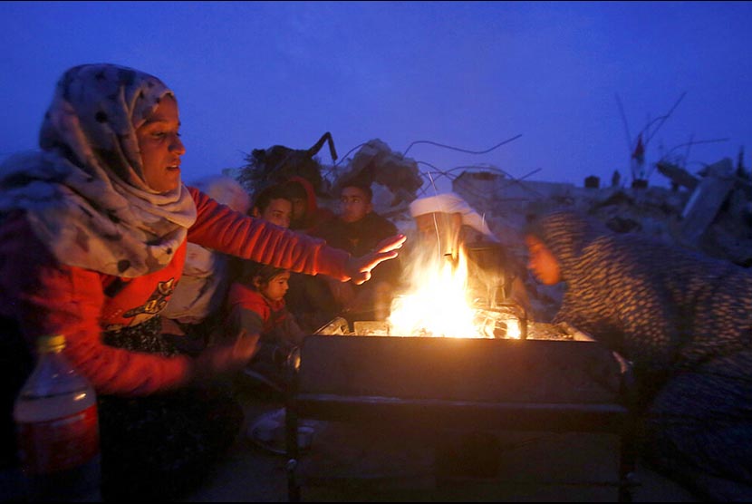 Satu keluarga berkumpul mengelilingi api unggun untuk mengusir dingin (ilustrasi).
