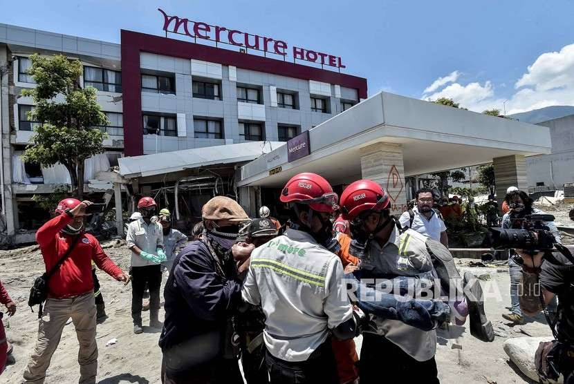 Keluarga korban dibawa petugas usai menyaksikan jenazah keluarganya yang menjadi korban gempa tsunami Palu di Hotel Mercure, Palu, Sulawesi Tengah, Jumat (5/10). 