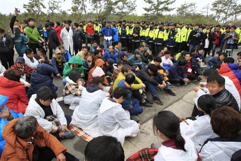 Keluarga korban kapal Sewol yang tenggelam di Laut Jindo sesaat sebelum melakukan long march ke istana presiden untuk memprotes tim penyelamat pemerintah yang dinilai lamban dalam mengevakuasi korban, Ahad (20/4).