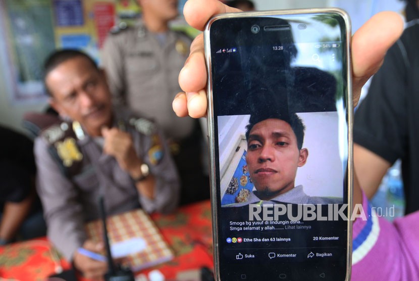 Keluarga korban kapal tenggelam KM Sinar Bangun menunjukkan foto anggota keluarganya yang merupakan penumpang hilang bernama Sarsubhan alias Yusuf, di posko Pelabuhan Tigaras, Simalungun, Sumatera Utara, Rabu (20/6).