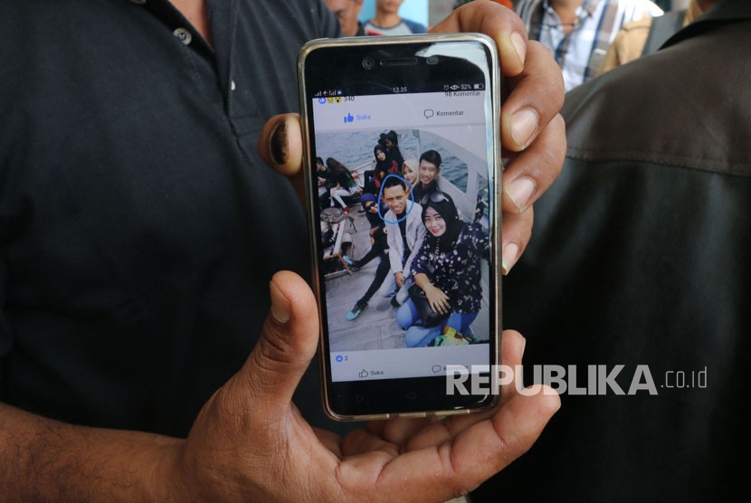 Keluarga korban kapal tenggelam KM Sinar Bangun menunjukkan foto anggota keluarganya yang merupakan penumpang hilang bernama Sarsubhan alias Yusuf (kedua kanan), di posko Pelabuhan Tigaras, Simalungun, Sumatera Utara, Rabu (20/6).