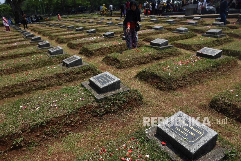 Keluarga korban menabur bunga di permakaman massal korban tragedi Mei 1998 di TPU Pondok Rangon, Jakarta, Ahad (13/5).