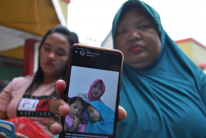Keluarga korban menunjukkan foto Yunita Sari (30) dan kedua anaknya Farisa (10) dan Runisa Syakila (2) yang menjadi korban kebakaran pabrik korek api saat menunggu proses identifikasi jenazah di Rumah Sakit Bhayangkara Polda Sumut, di Medan, Sumatera Utara, Jumat (21/6/2019).