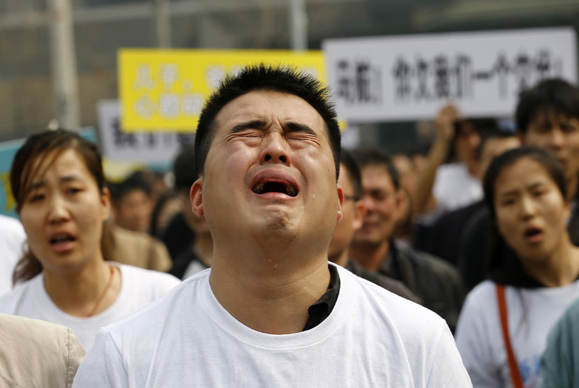  Keluarga korban penumpang pesawat Malaysia Airlines MH370  menangis saat berunjuk rasa di depan gedung Kedubes Malaysia di Beijing, Selasa (25/3).  