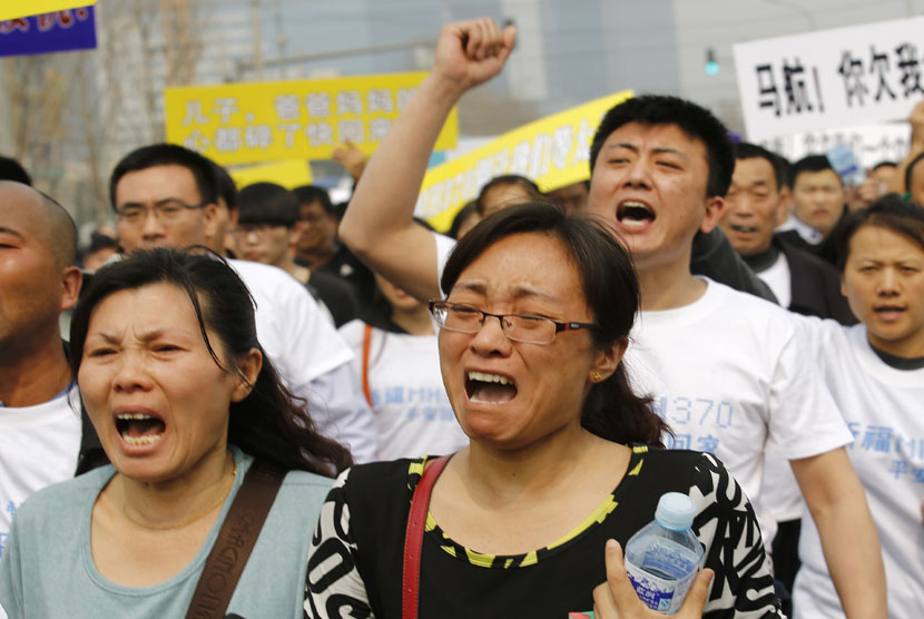  Keluarga korban penumpang pesawat Malaysia Airlines MH370  berunjuk rasa di depan gedung Kedubes Malaysia di Beijing, Selasa (25/3).   (Reuters/Kim Kyung-Hoon)