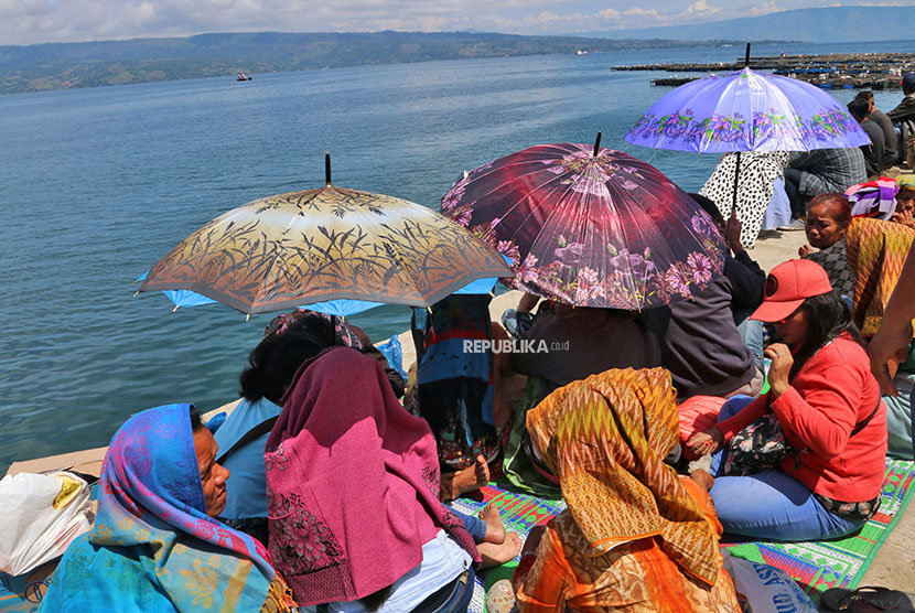 Keluarga korban tenggelamnnya KM Sinar Bangun menunggu di dermaga Pelabuhan Tigaras, Danau Toba, Simalungun, Sumatera Utara, Jumat (22/6).