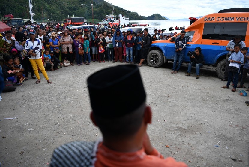 Keluarga korban tenggelamnya KM Sinar Bangun bersama warga mengikuti doa lintas agama di dermaga Tigaras, Danau Toba, Simalungun, Sumatera Utara, Minggu (1/7).