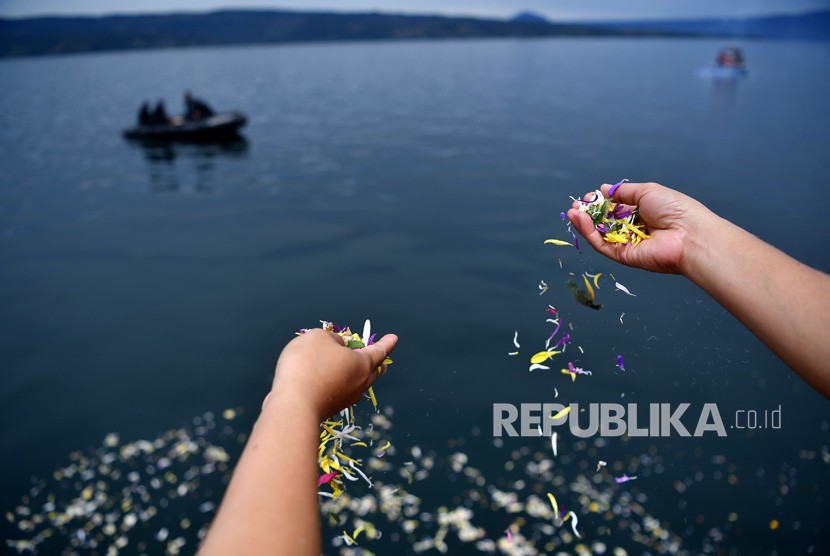 Keluarga korban tenggelamnya KM Sinar Bangun menabur bunga di kawasan titik tenggelamnya kapal di Danau Toba, Sumatera Utara, Senin (2/7).
