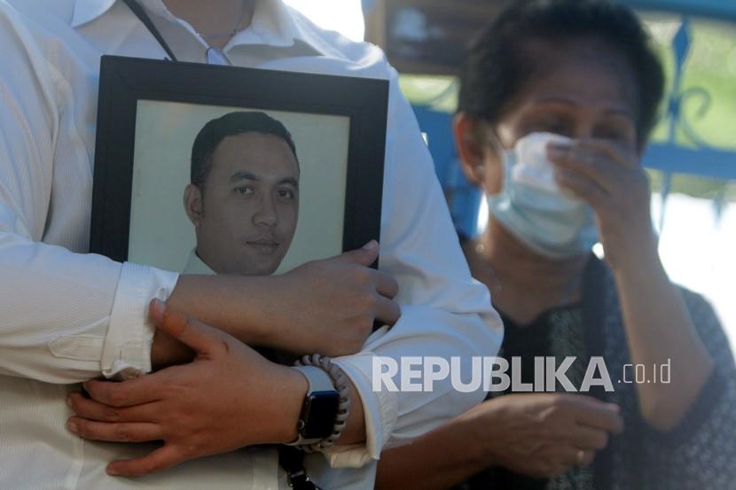 Keluarga membawa bingkai foto Ricko Damianus Mahulette saat dimakamkan di Tempat Pemakaman Kristen Panaikang, Makassar, Sulawesi Selatan, Sabtu (16/1/2021). Ricko Damianus Mahulette merupakan salah satu korban kecelakaan pesawat Sriwijaya Air dengan nomor penerbangan SJ 182 rute Jakarta-Pontianak yang berhasil diidentifikasi oleh tim Disaster Victim Identification (DVI) Polri.